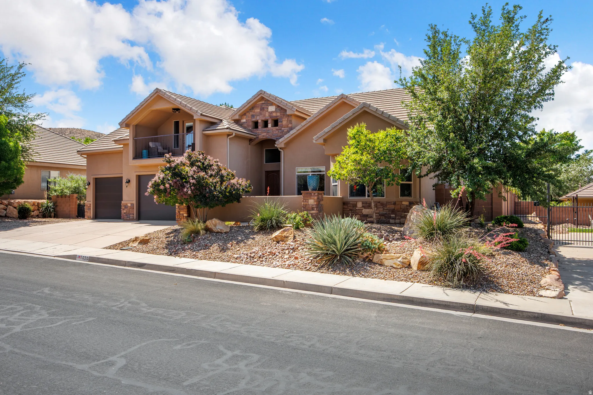 Stucco exterior with stone accents and a tiled roof