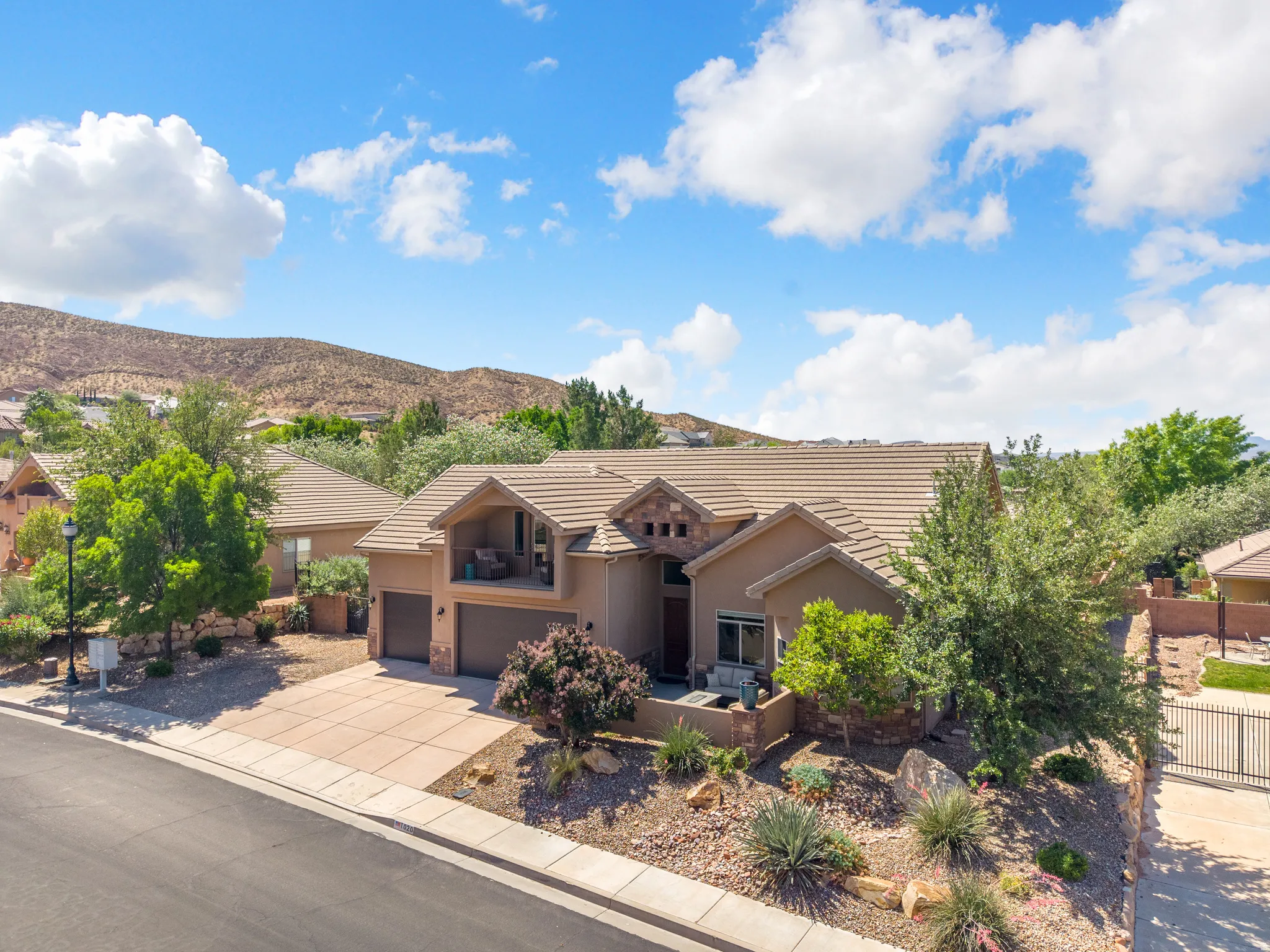 Stucco exterior featuring a tiled roof and integrated two-car garage
