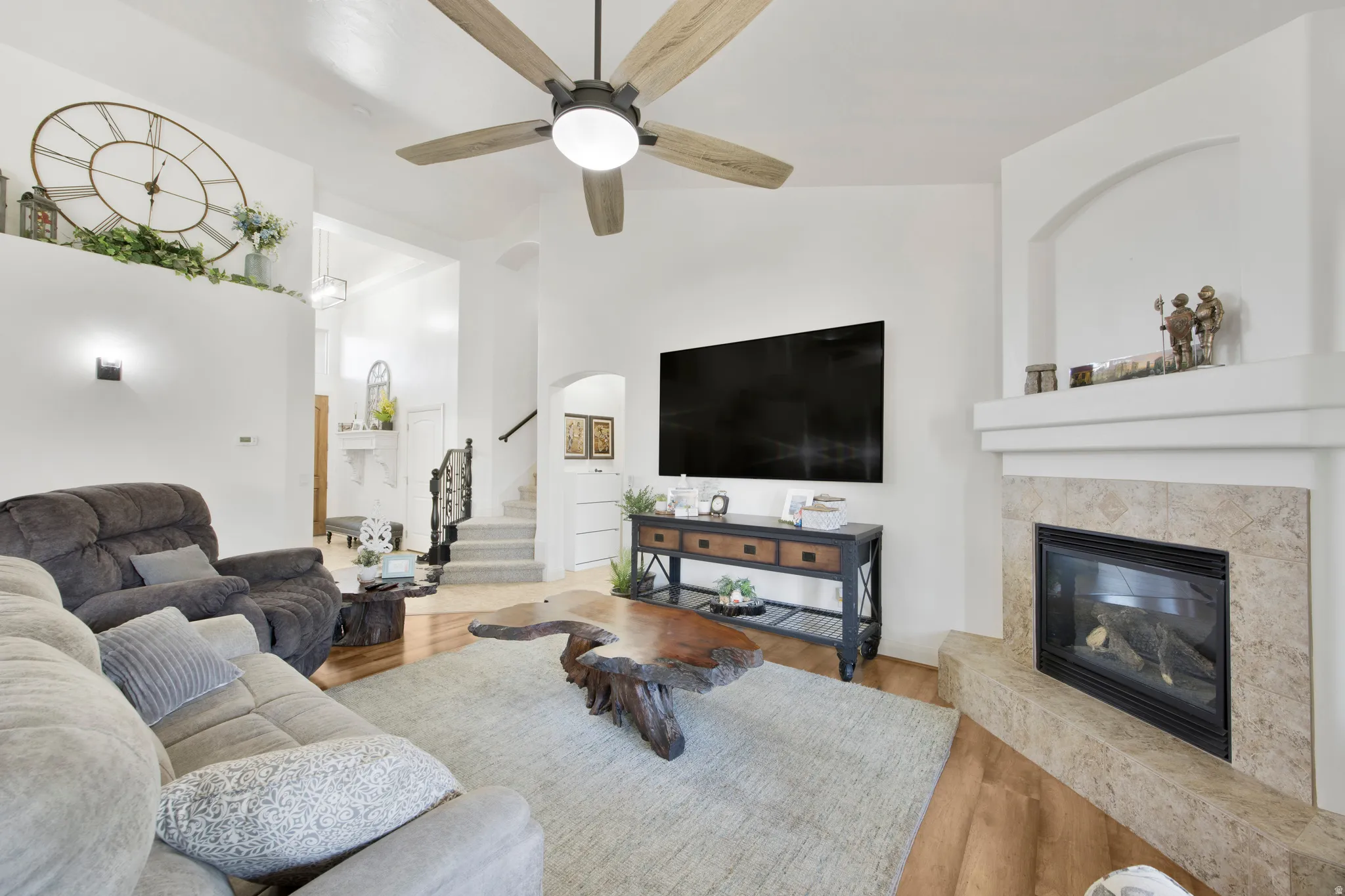 Living area featuring wood-finish flooring and a corner fireplace with a tiled surround
