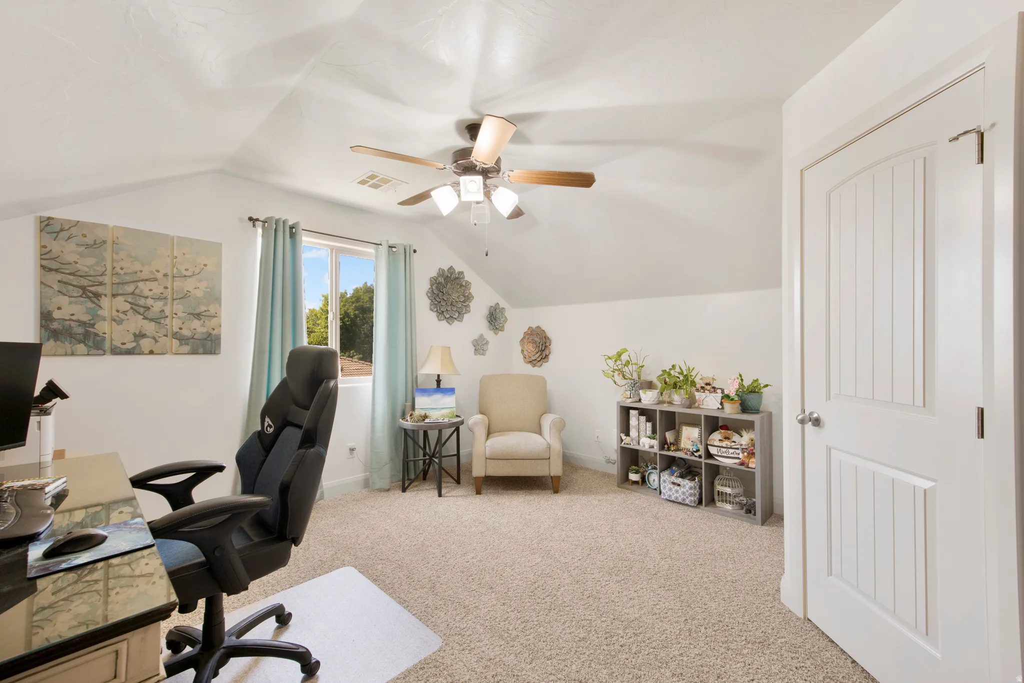Versatile bonus room featuring a window with natural light, sloped ceilings, and a ceiling fan
