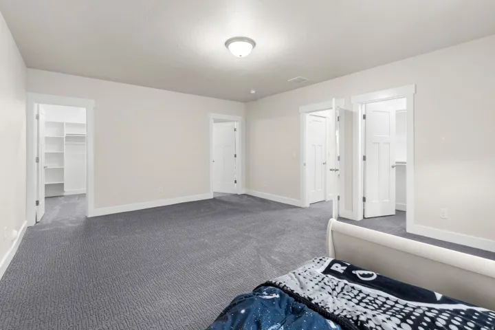 Spacious room with plush gray carpeting, neutral wall finishes, and white trim