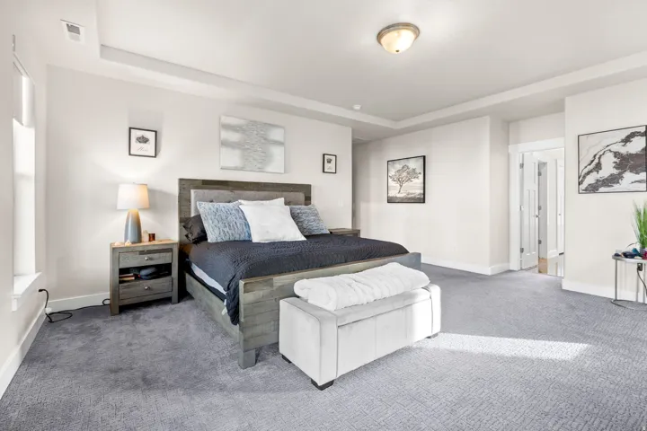 Spacious carpeted room featuring a tray ceiling, recessed lighting, and white baseboards