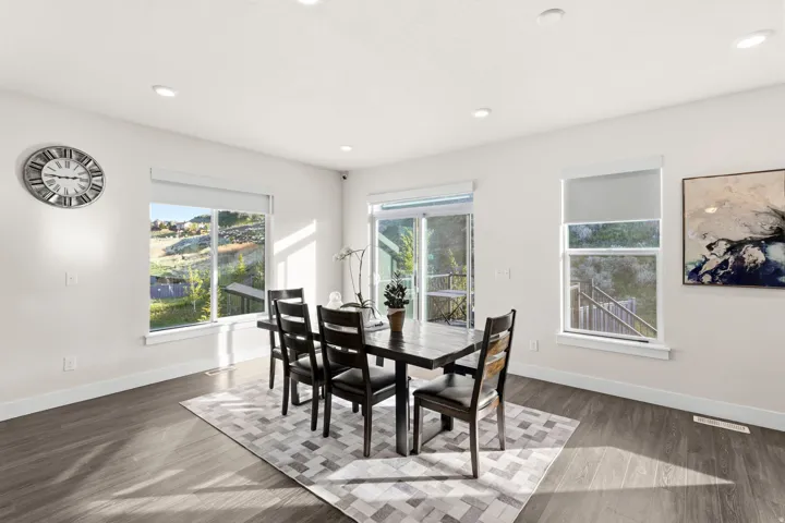Spacious dining area featuring wood-finish flooring, recessed lighting, and white baseboards