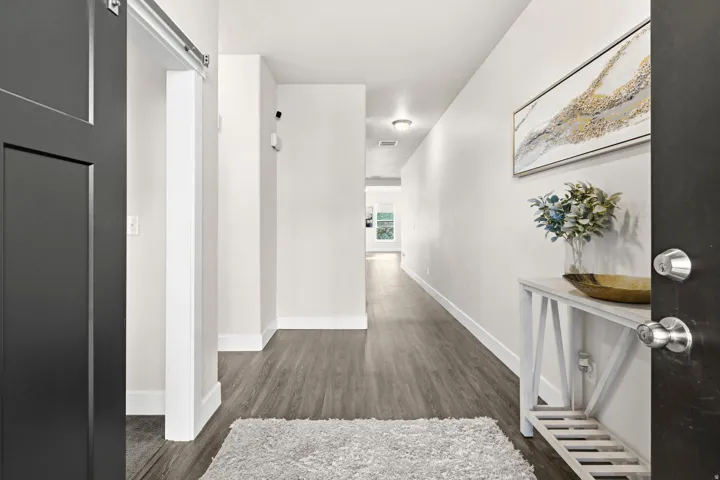 Entryway featuring dark wood-finish flooring, white baseboards, and bright overhead lighting