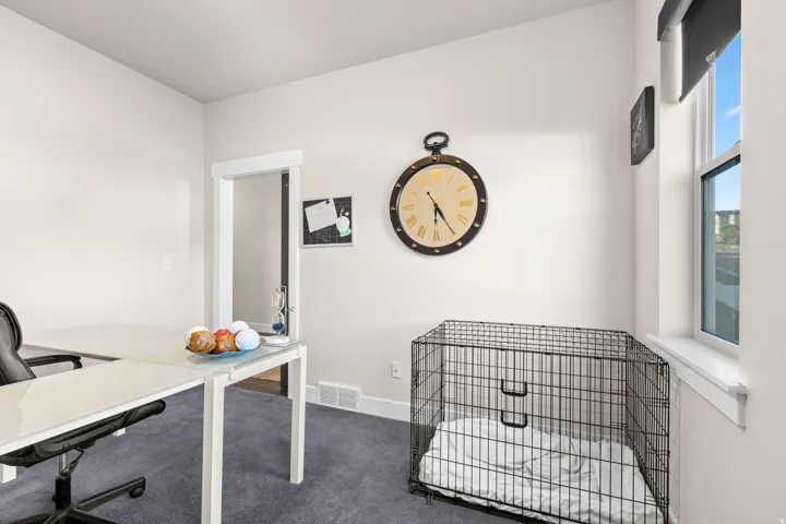Carpeted room with a single window, white walls, and a doorway with white trim