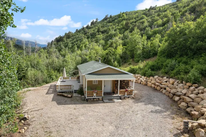 Front of property featuring a forest view, a mountain view, and a porch.