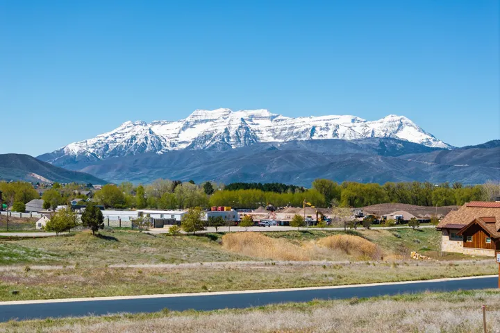 Expansive mountain range backdrop, featuring snow-capped peaks and surrounding foothills
