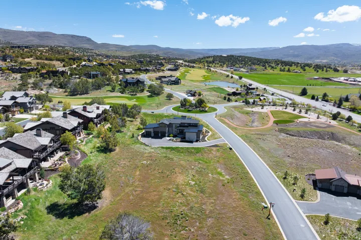 Expansive residential development featuring paved roadways, individual properties with multi-story structures, and surrounding natural landscapes