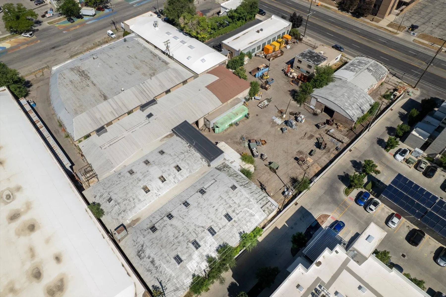 Extensive commercial property featuring multiple structures, corrugated metal roofing, and a large paved lot