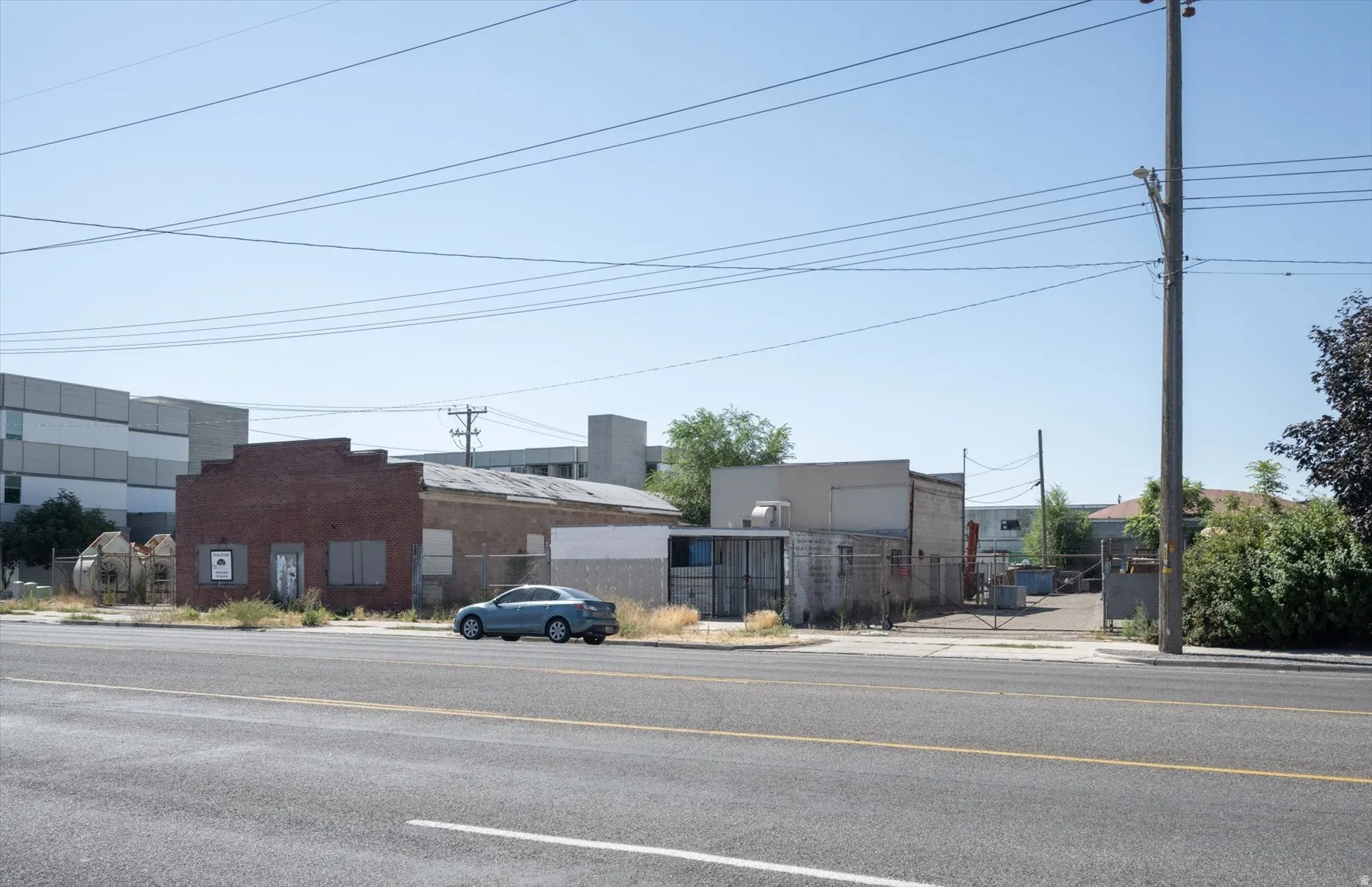 Brick-front commercial building with multiple structures and a fenced lot