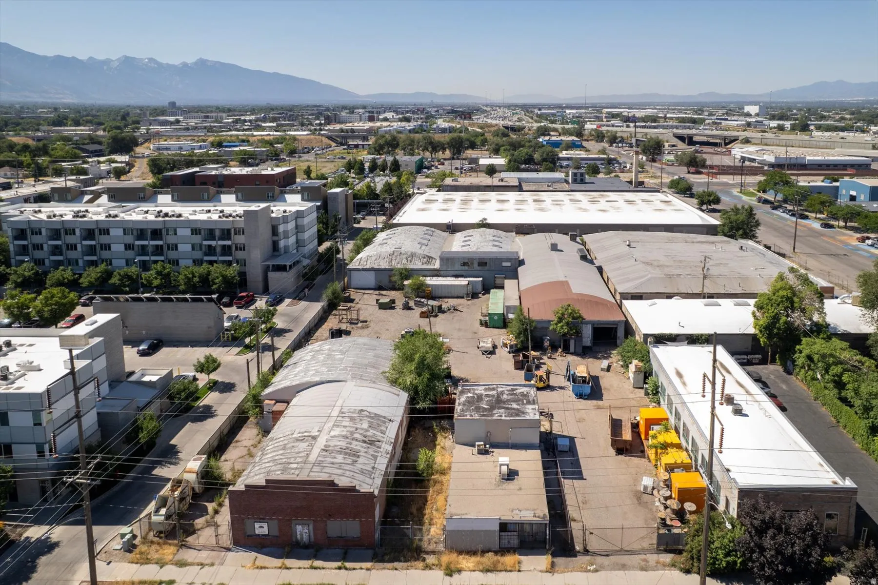 Expansive commercial property featuring multiple industrial buildings with various roof styles including flat and arched designs