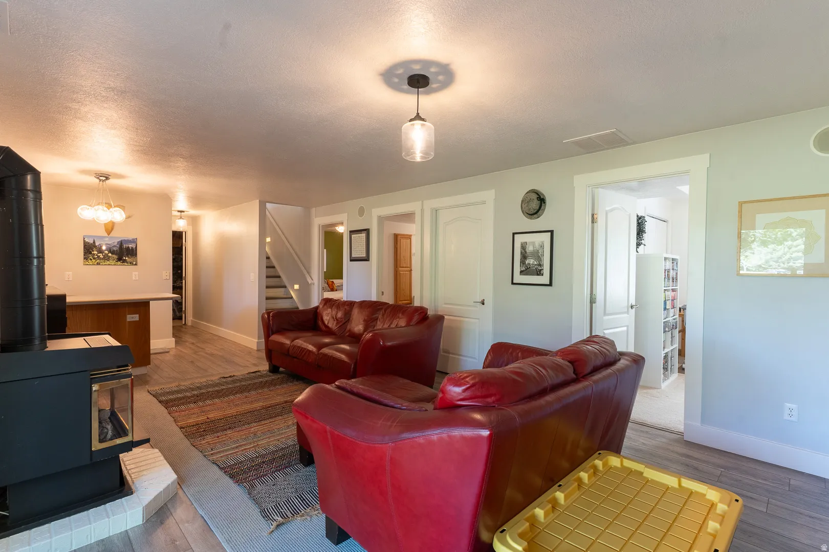 Living area featuring a wood-burning stove with a tile hearth.  There is a laundry hook-up in the basement!