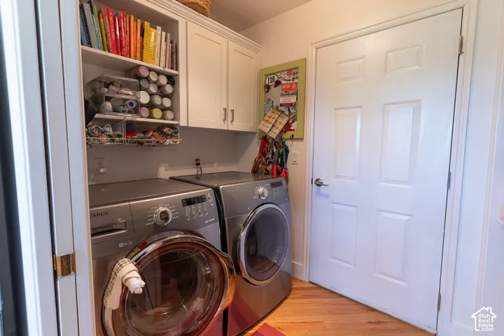 Laundry area featuring built-in cabinetry, open shelving, and wood-finish flooring inside the garage door