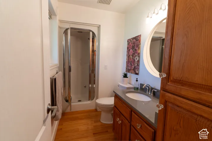 Three quarter bathroom, with wood floor, a glass-enclosed shower - steamer!!  Nice touches with mirror and design.