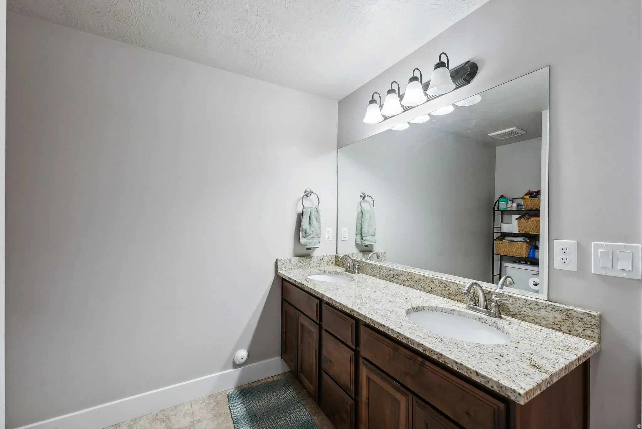 Double vanity with granite-style countertop, dual undermount sinks, and brushed nickel faucets