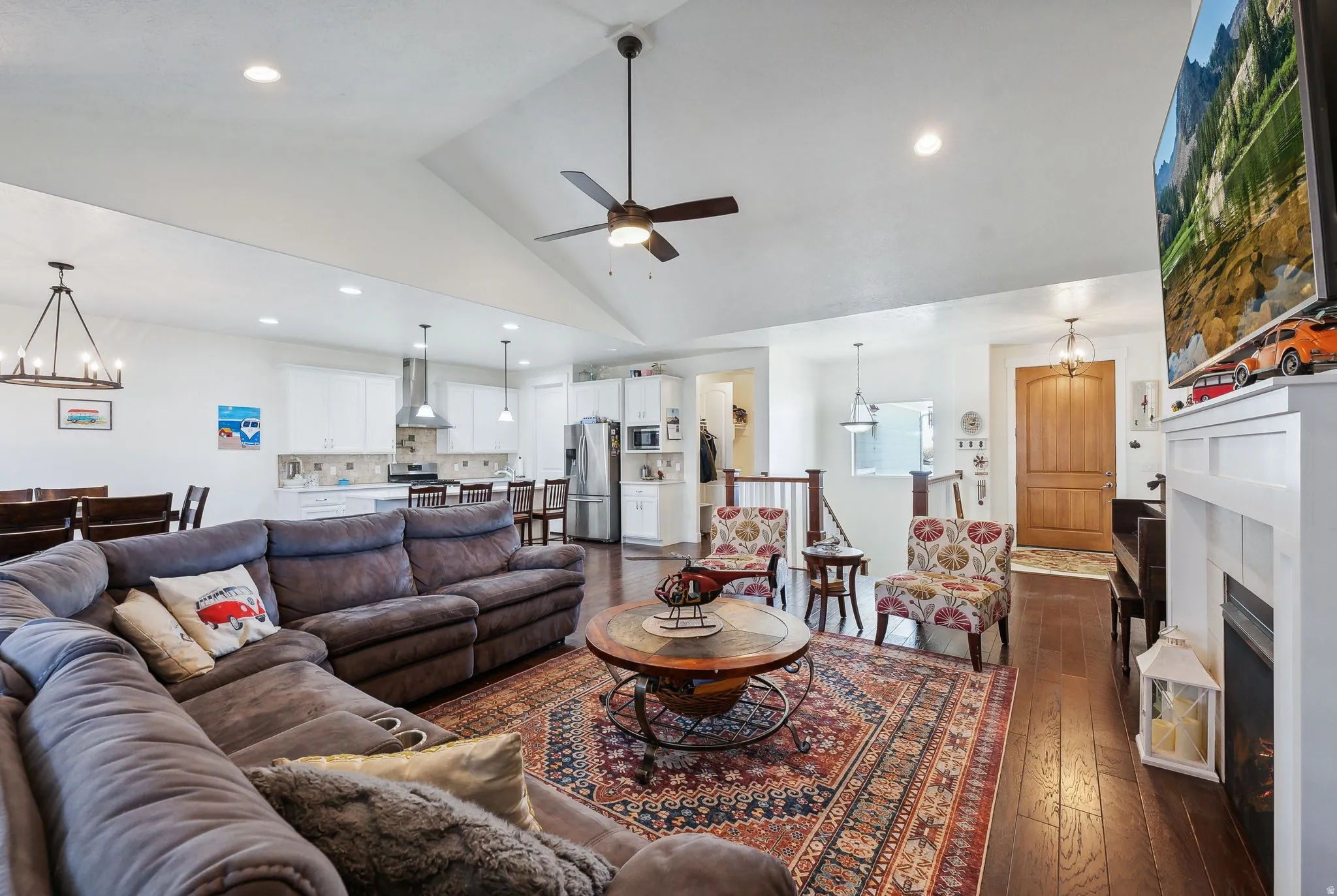 Open-concept living area with vaulted ceilings, recessed lighting, and rich wood-finish flooring