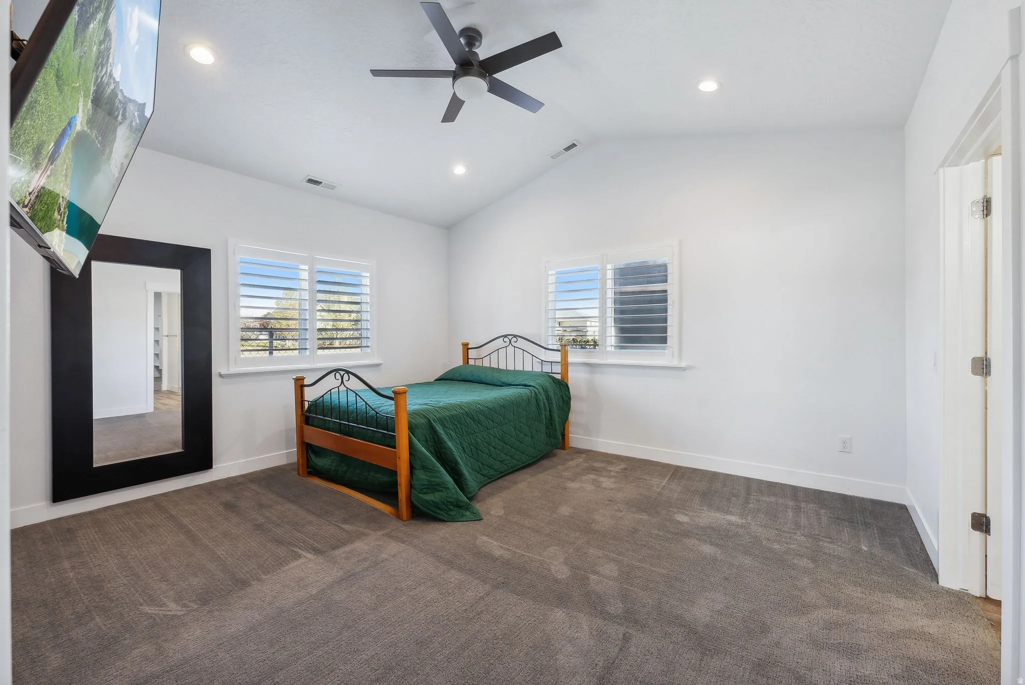 Custom built ADU/Spacious room featuring vaulted ceilings, recessed lighting, and soft gray carpeting