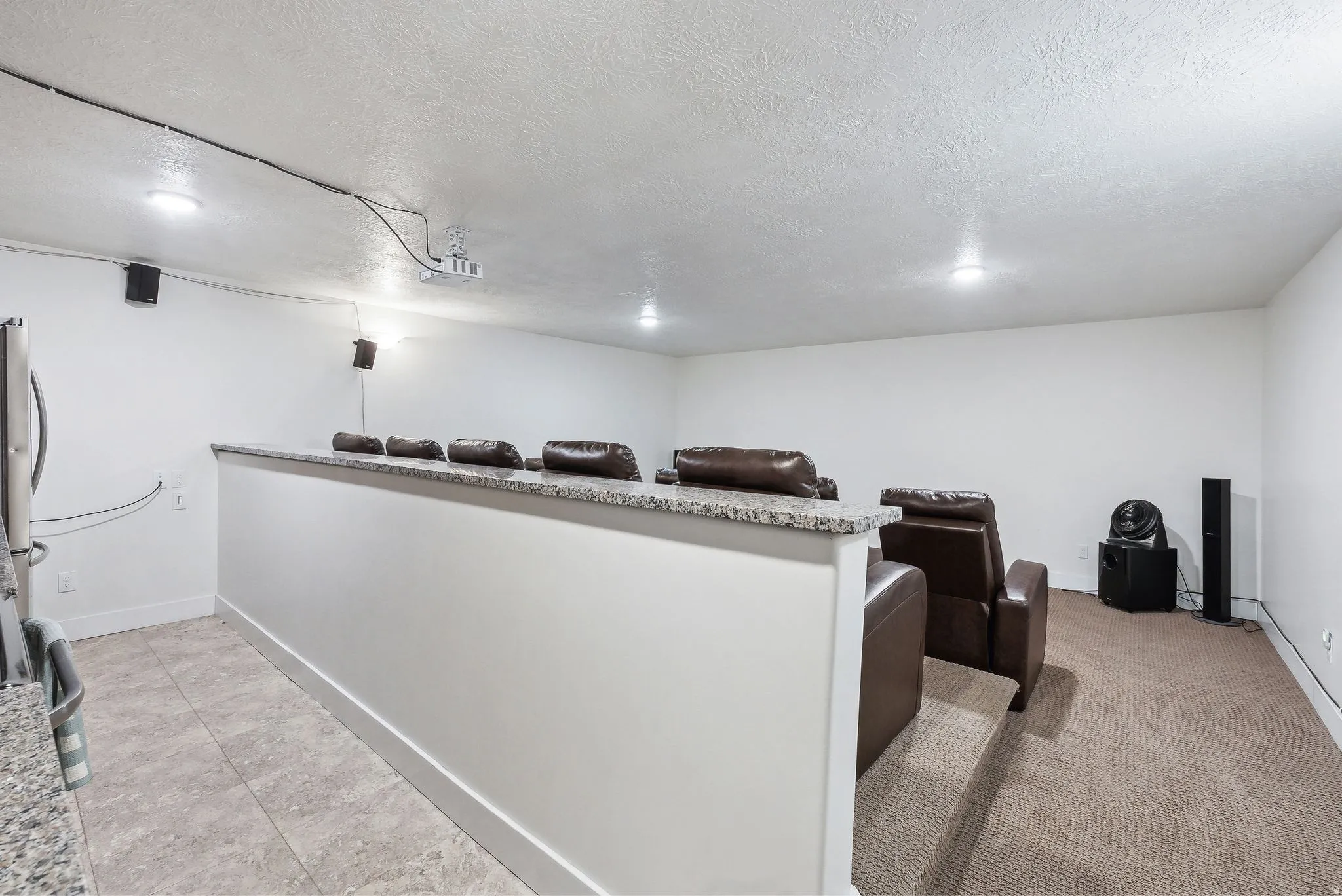 Theatre with full kitchen/Carpeted entertainment area featuring a raised seating platform