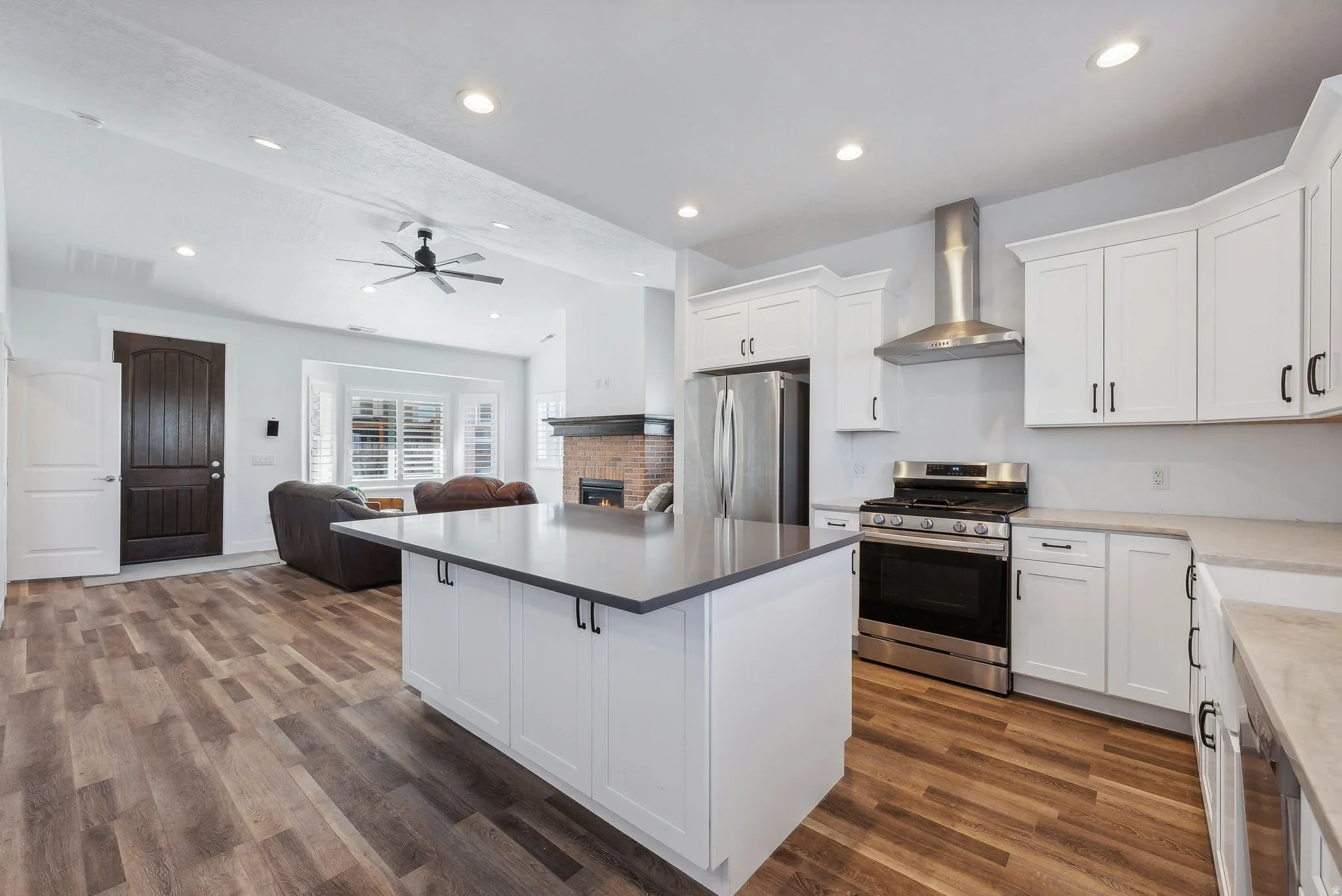Custom built ADU/Modern kitchen featuring white cabinetry, stainless steel appliances, a center island with a dark countertop, wood-finish flooring, and recessed lighting