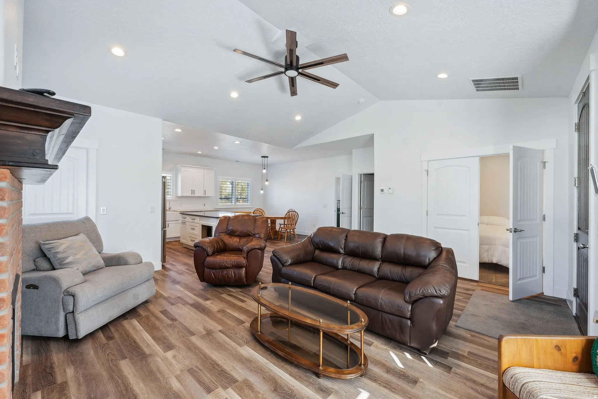 Custom built ADU/Open concept living area featuring vaulted ceilings, wood-finish flooring, recessed lighting, and a prominent ceiling fan