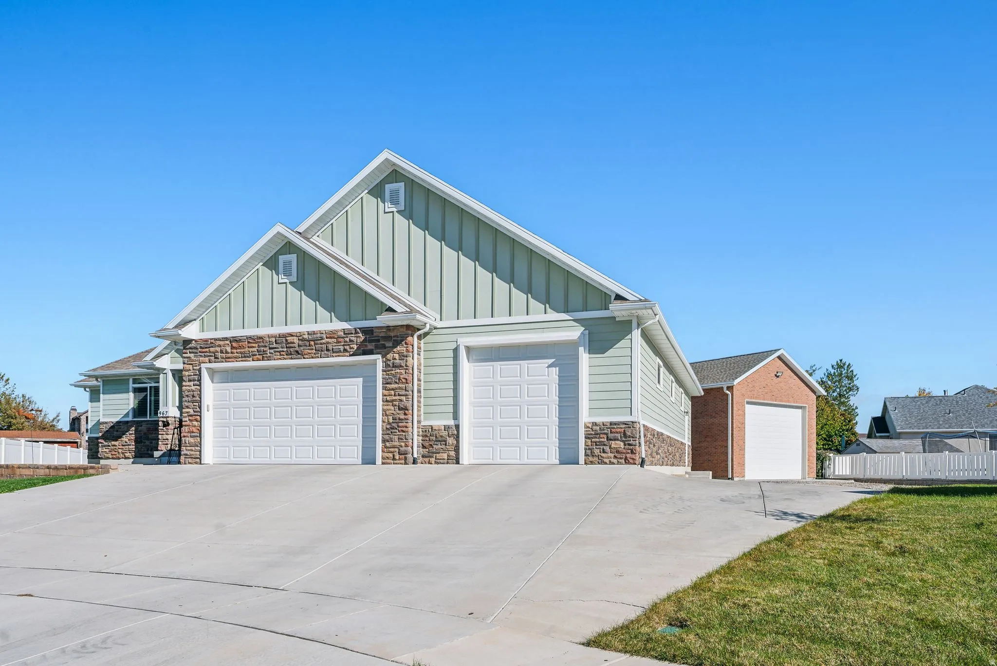 Three garage doors with concrete driveways