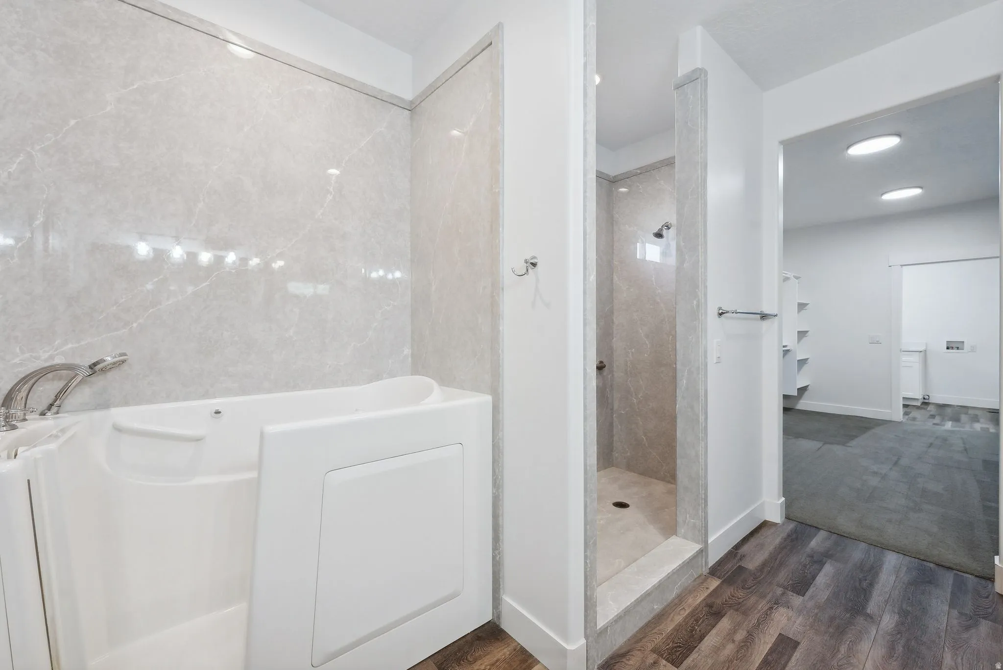 Custom built ADU/Bathroom featuring a walk-in tub and a separate shower with stone-look wall panels