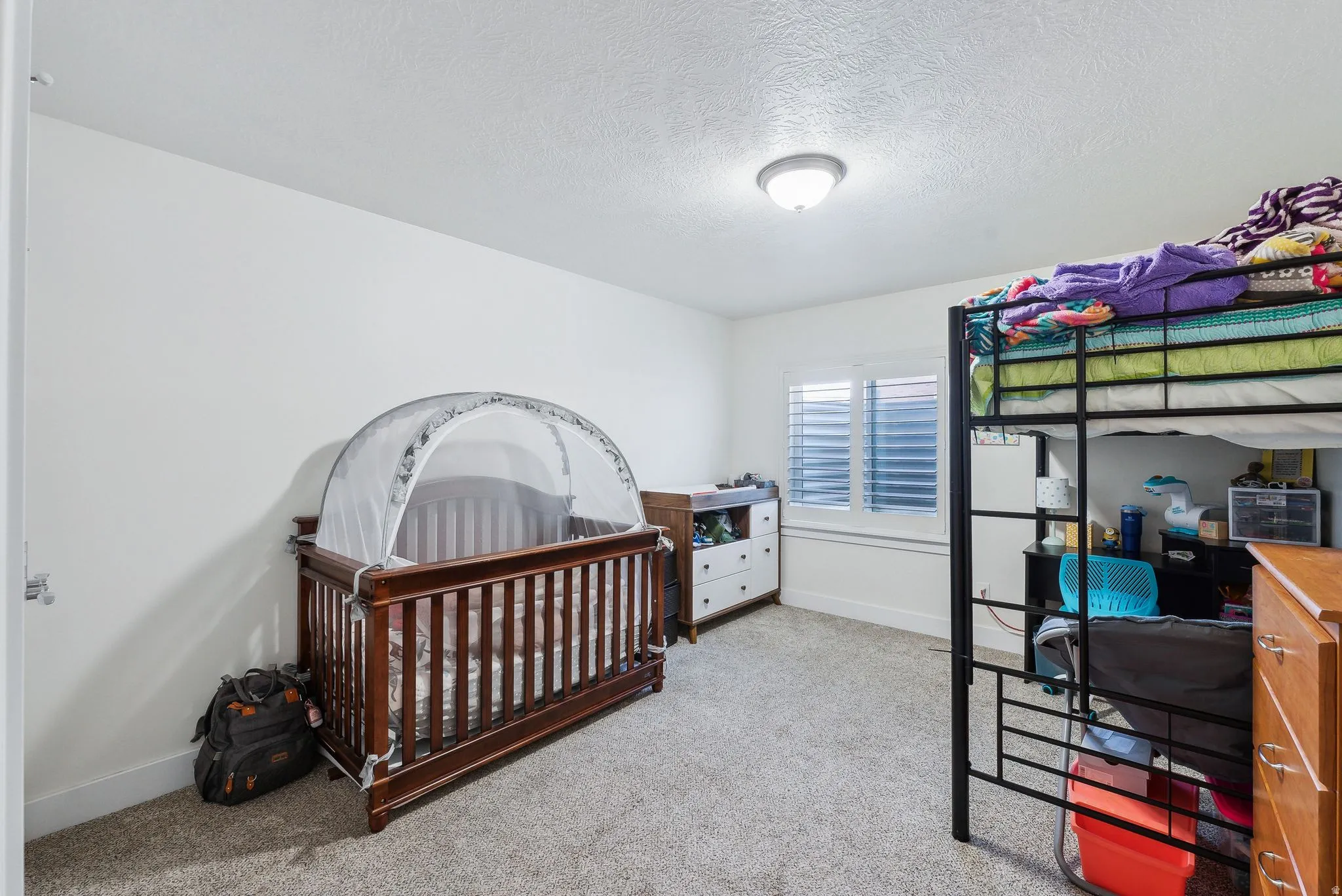 Room featuring light neutral wall paint, textured ceiling, and soft carpet flooring