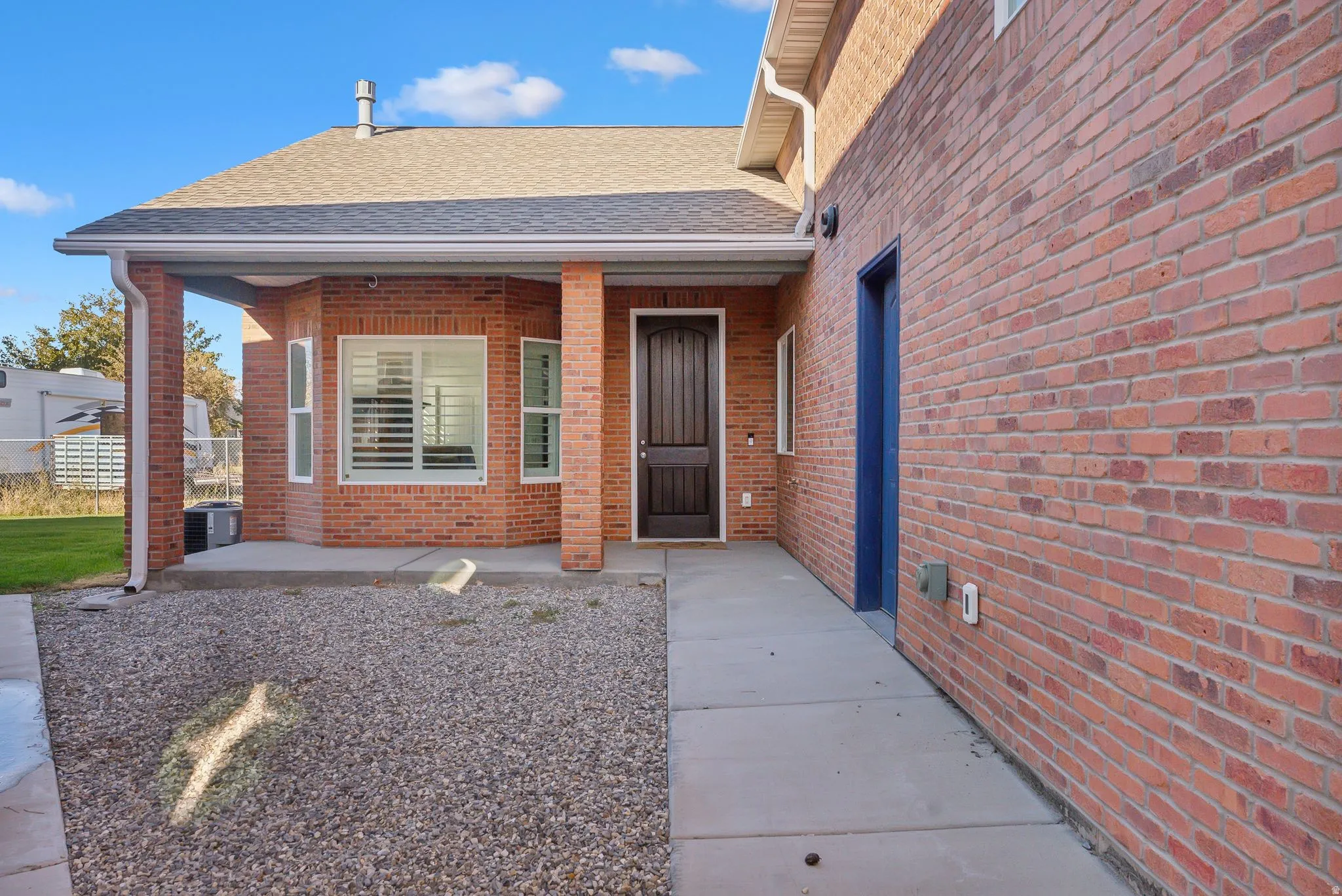 Custom built ADU/Brick exterior with covered front entry and dark wood-finish door