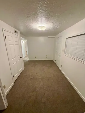 Carpeted interior space featuring white walls and white trim
