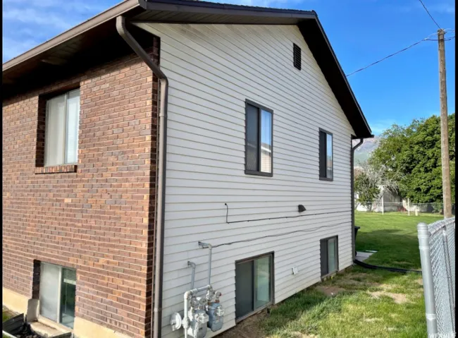 Exterior featuring a combination of red brick and light-colored siding