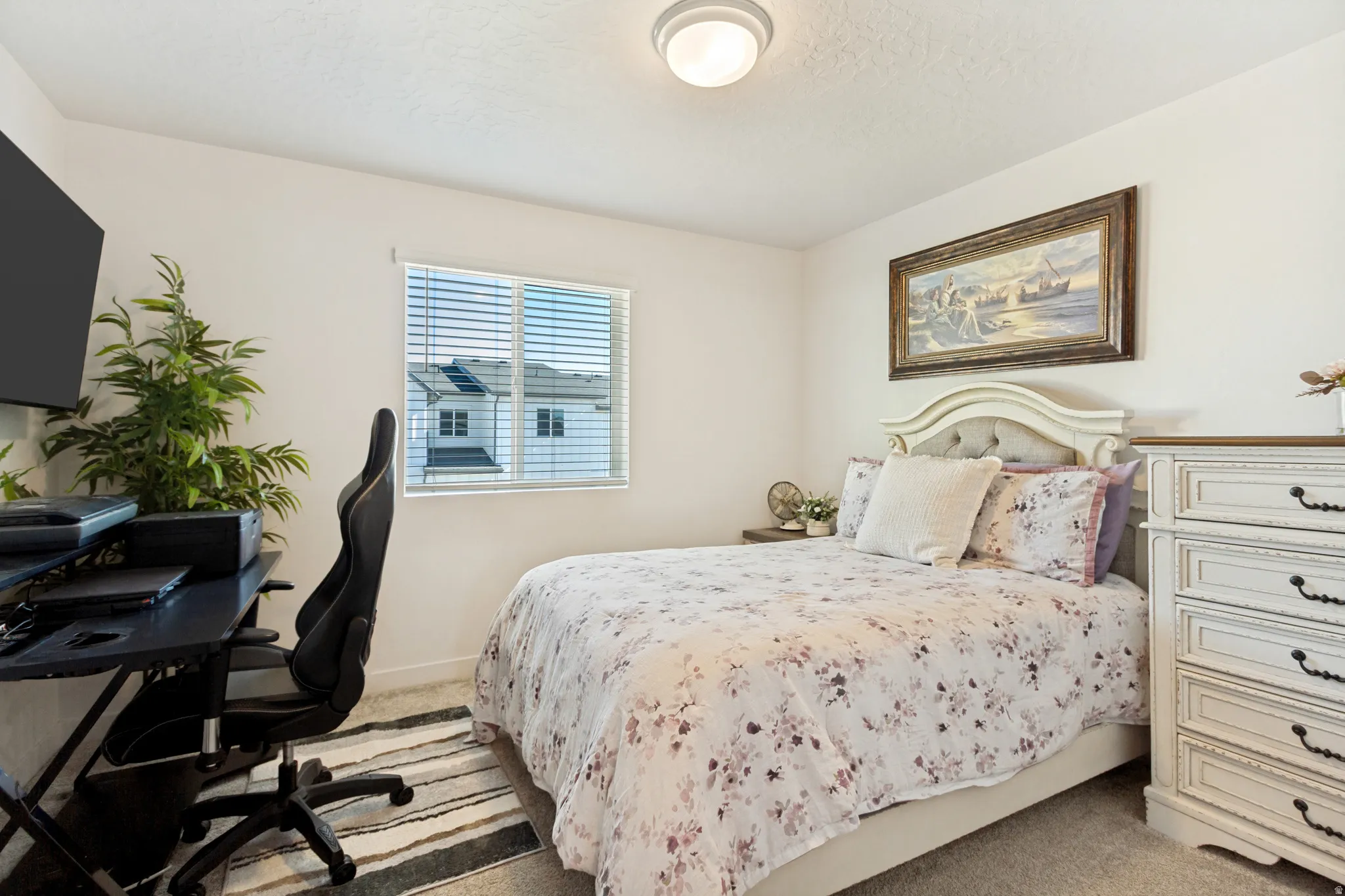 Comfortable bedroom featuring soft gray carpeting and a neutral wall color