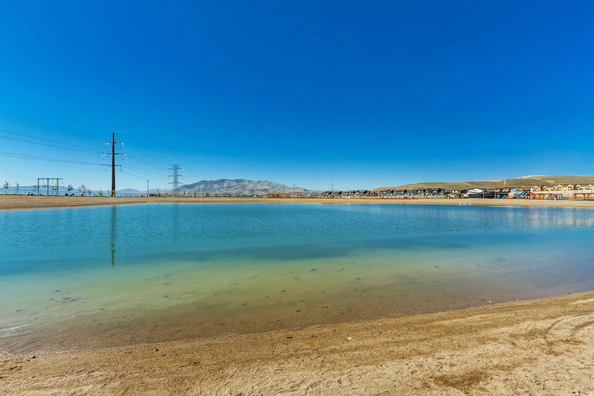 Expansive calm water body with a sandy shore