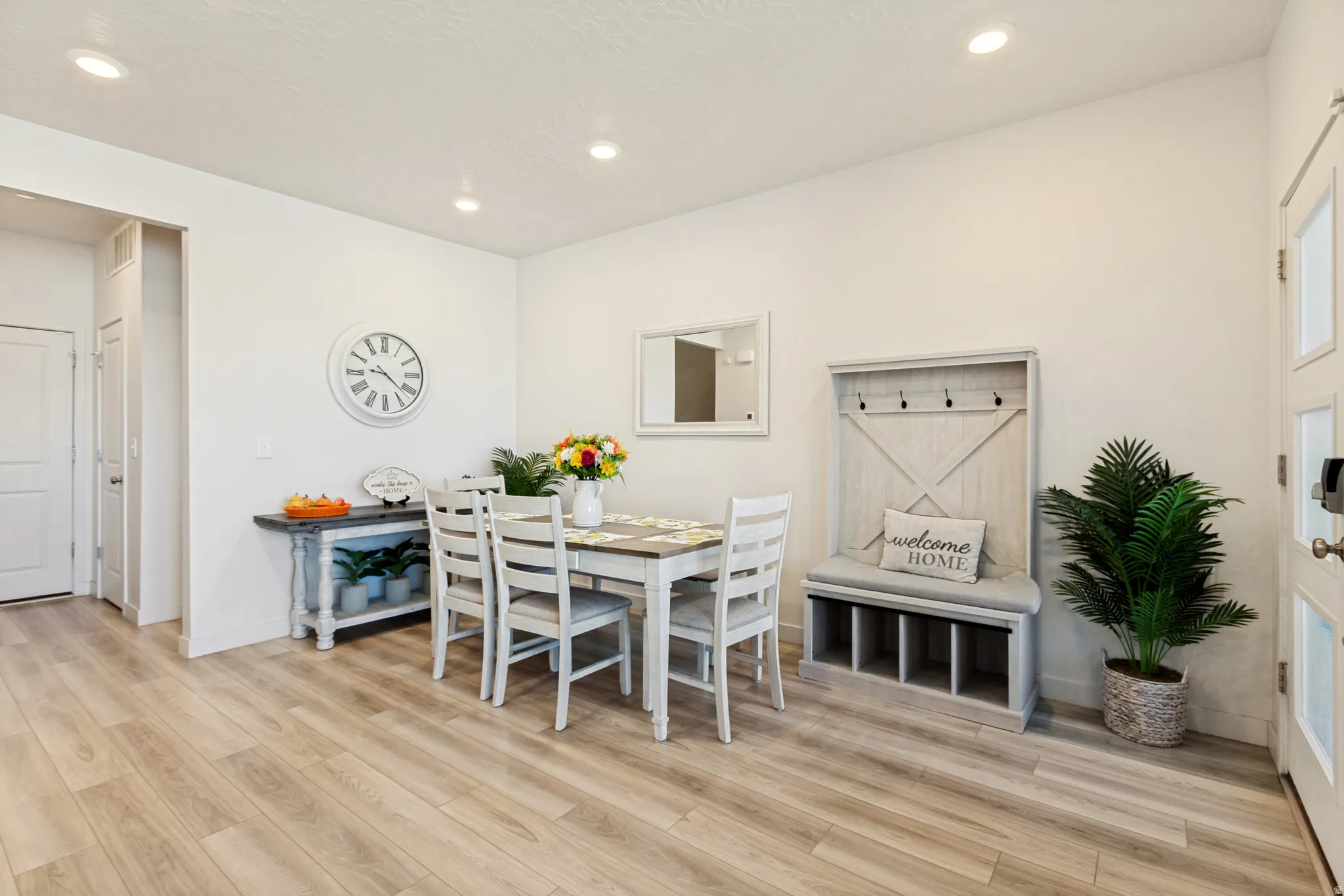 Open-concept dining area featuring light-tone wood-finish flooring and recessed lighting