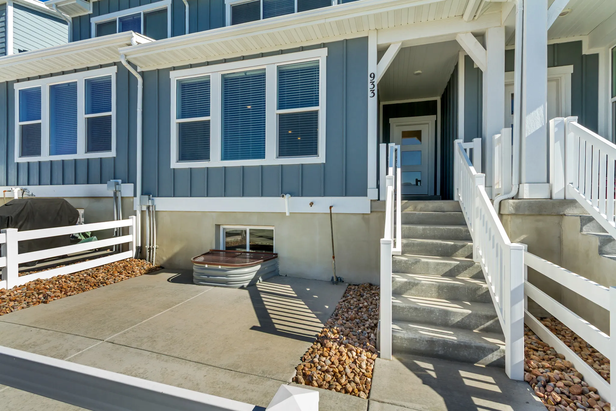 Entryway featuring a modern front door with frosted glass panels, an elevated concrete staircase with white railings, and a covered porch