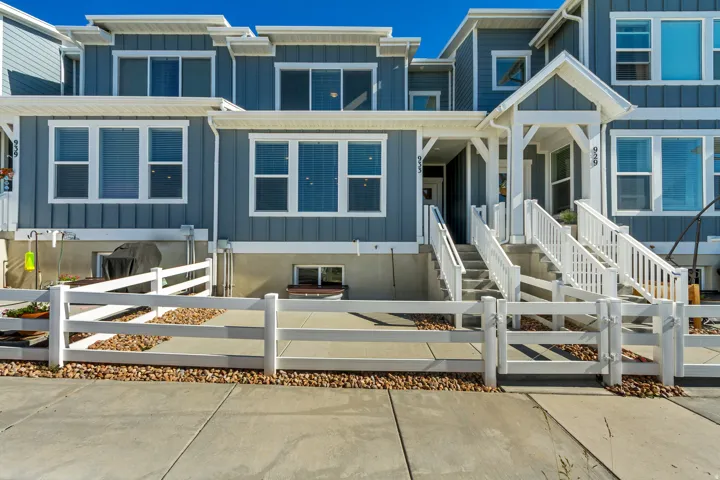 Modern townhome exterior featuring blue vertical siding with white trim