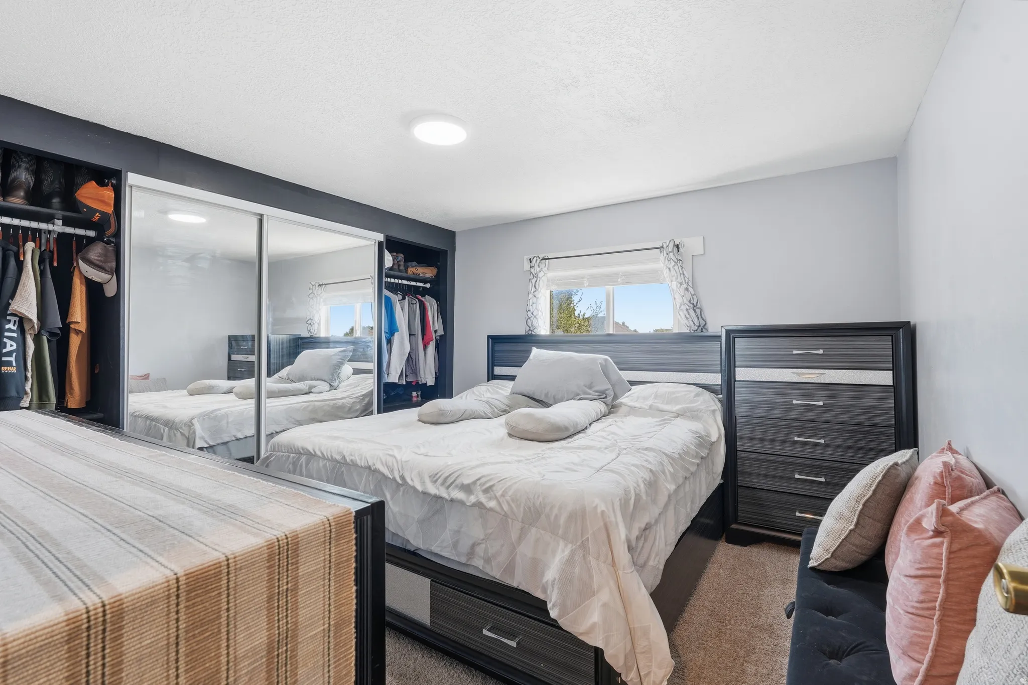 Bedroom featuring a window, recessed lighting, and built-in closet storage with mirrored sliding doors