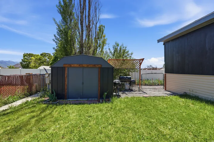 Expansive rear yard featuring a metal storage shed, gravel patio area, and perimeter fencing