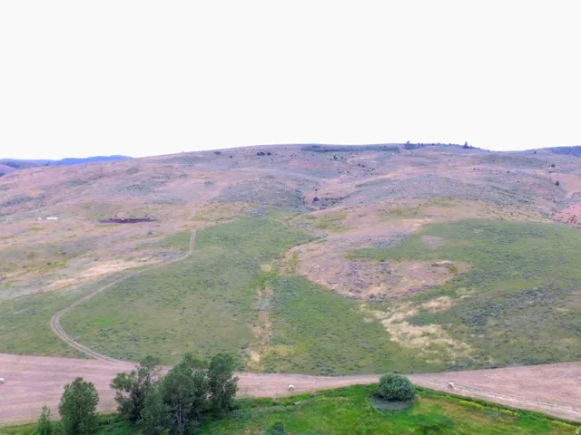 Expansive rolling hills featuring natural terrain and distant foliage