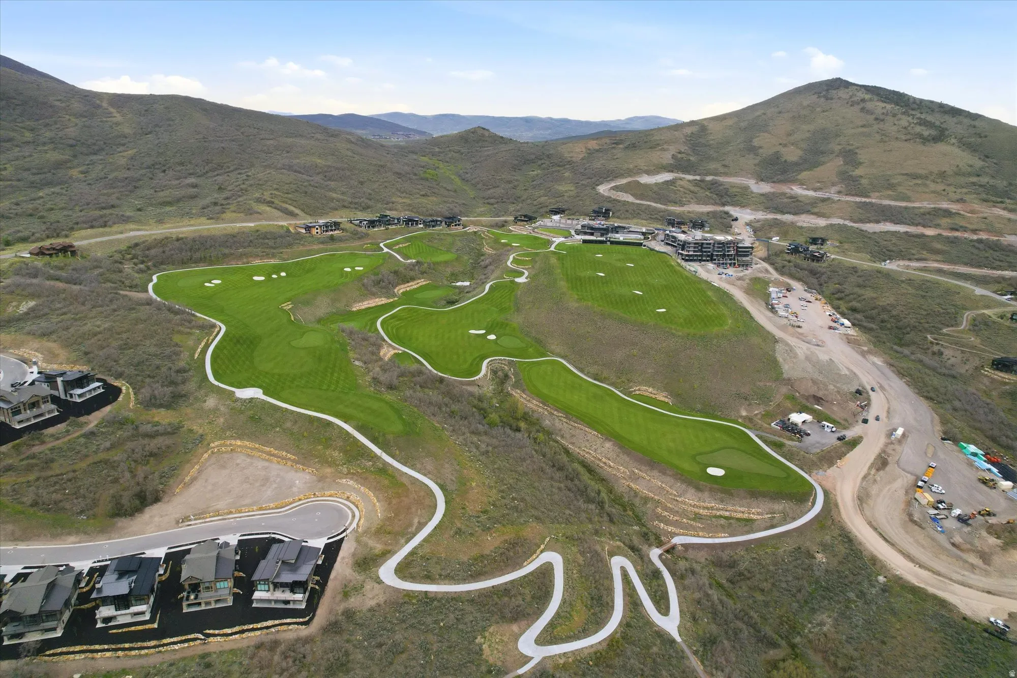 Expansive golf course setting featuring manicured greens and surrounding natural terrain