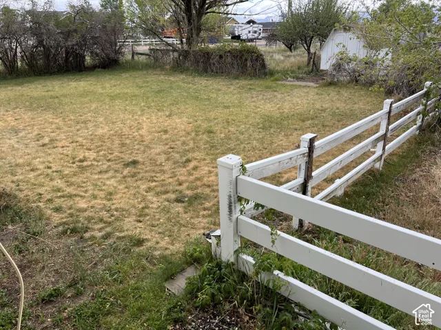 Expansive property featuring a white fence