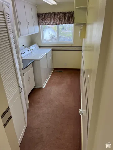 Laundry area featuring wall-mounted cabinetry, a built-in counter, and a window with natural light