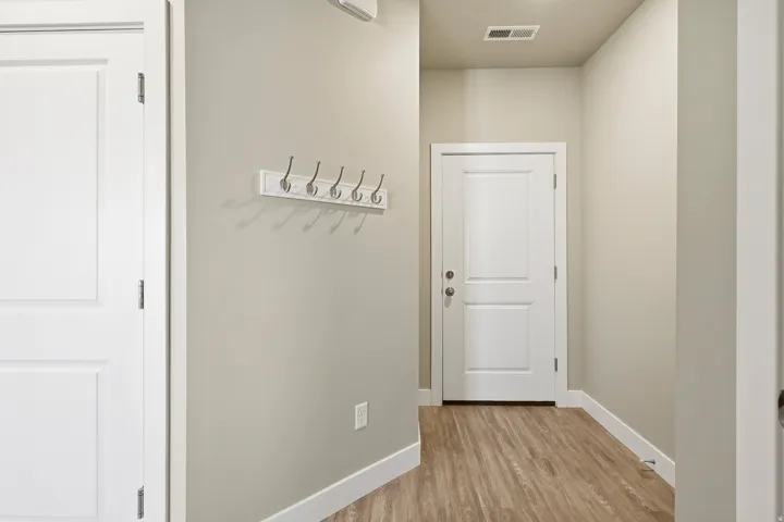 Entryway featuring wood-finish flooring, light neutral wall paint, and white trim