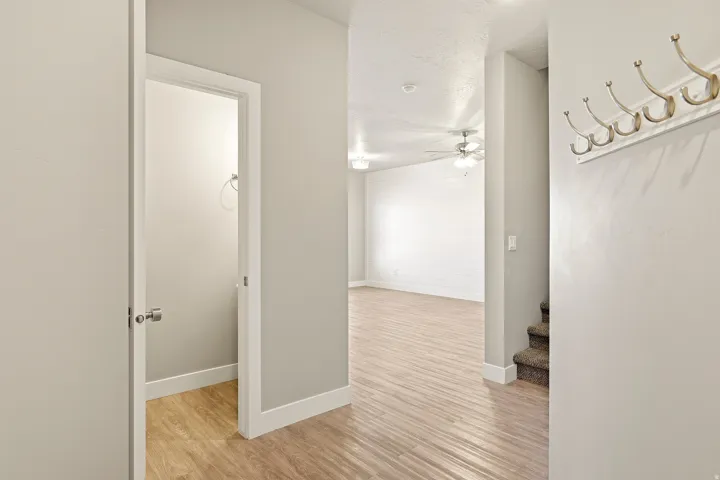 Entryway featuring wood-finish flooring, a built-in coat rack, and neutral-toned walls