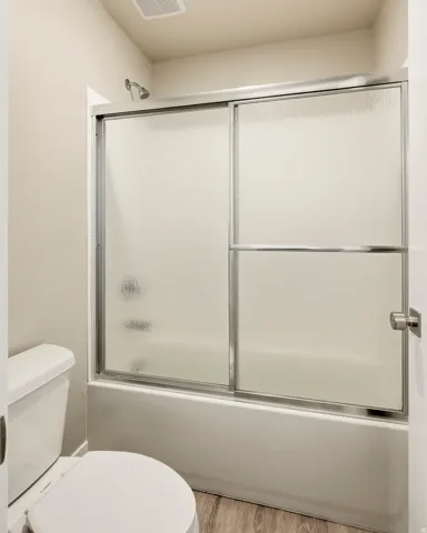 Shower-tub combination with sliding frosted glass doors and a chrome showerhead