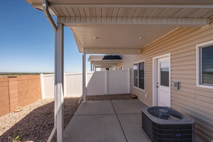 Covered concrete patio with horizontal vinyl siding and recessed lighting
