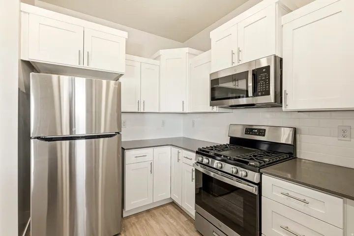 Kitchen featuring stainless steel appliances, white shaker-style cabinetry, a gas range with an oven, and a built-in microwave