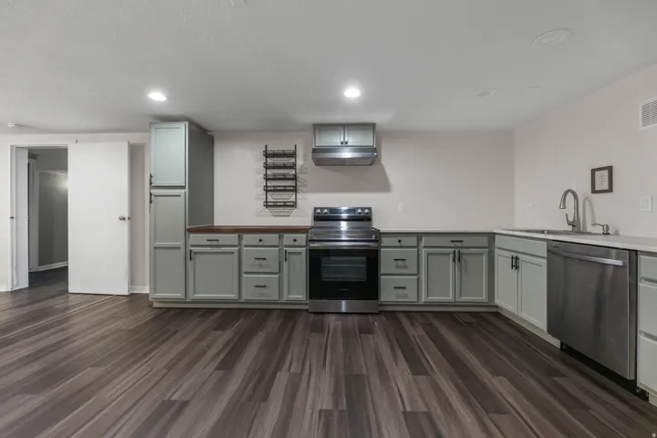 Kitchen / Break Room featuring ample cabinet and countertop space, sink, dishwasher and stove. Located in the bsmt of the North Bldg