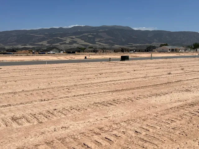 Expansive undeveloped land parcel featuring cleared ground with visible tire tracks