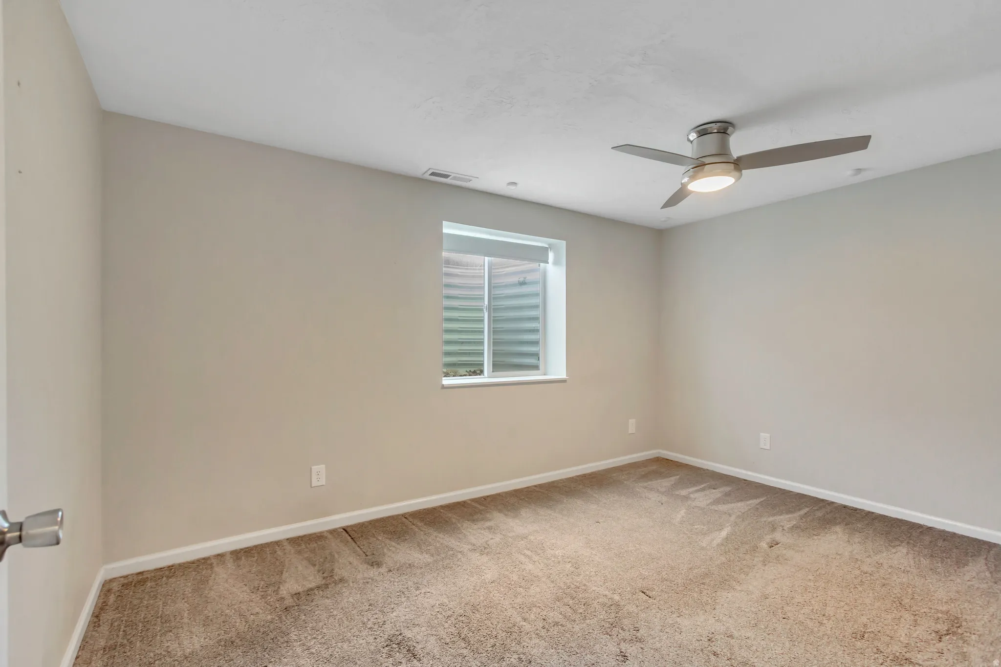 Neutral-toned wall paint with a window featuring a window well