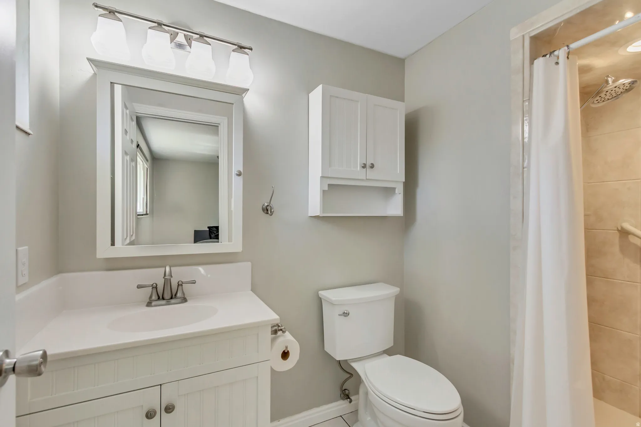 Bathroom featuring a white vanity with beadboard detailing, integrated sink, and brushed nickel faucet